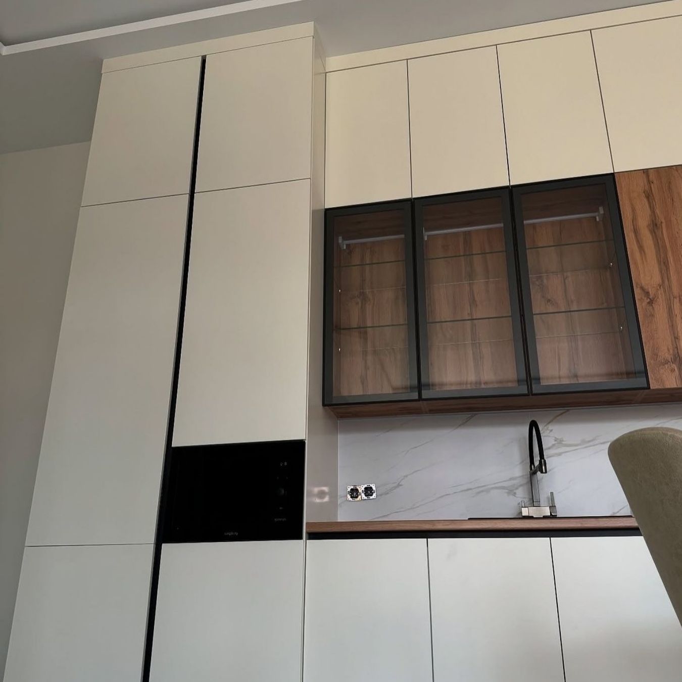 Cream kitchen with walnut glass display cabinets