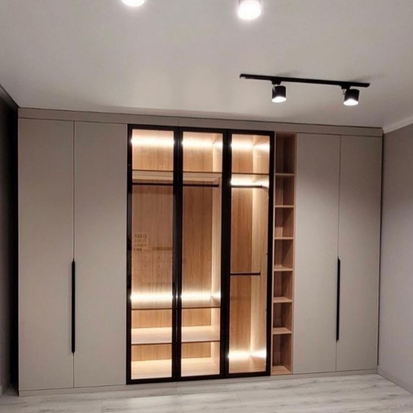 Black-framed glass wardrobe with LED-lit open shelving