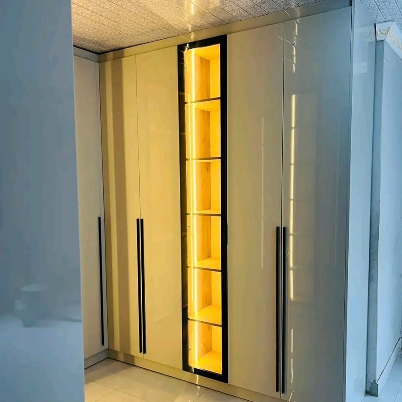 High-gloss wardrobe with illuminated open display column