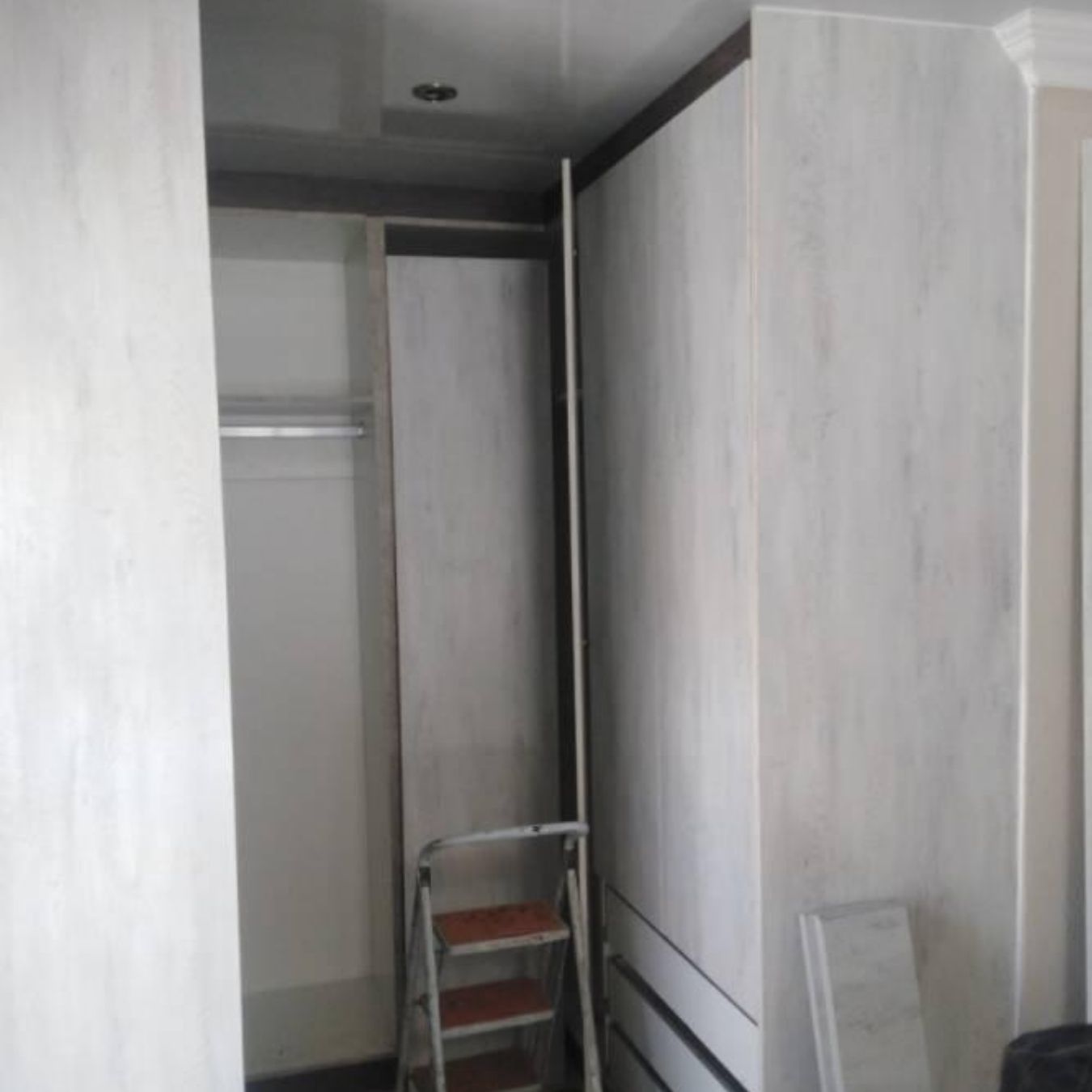 Compact walk-in wardrobe with hanging rail and drawers
